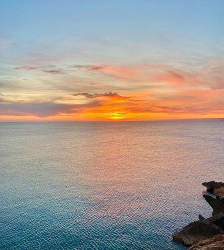 a sunset over a large body of water at SUNSET ROOM AT FRONT BEACH - HABITACION EN LA PLAYA en Piso compartido in Tavernes de Valldigna