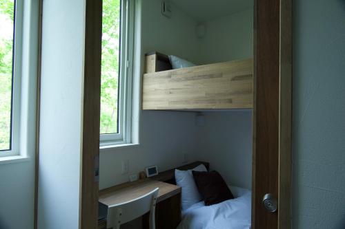 a room with a bunk bed and a table and a bed at HOTEL BOTH in Shari