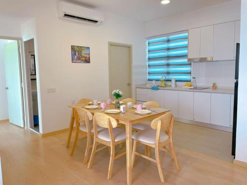 a kitchen and dining room with a wooden table and chairs at Mutiara Melaka Beach Resort by Minso in Tangga Batu