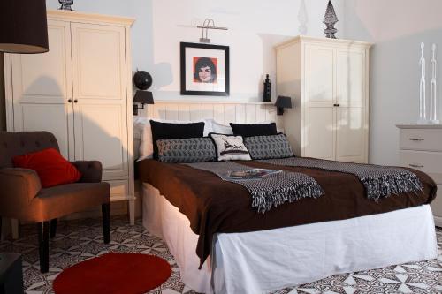 a bedroom with a large bed and a chair at Affittacamere Capri Dolce Vita in Capri