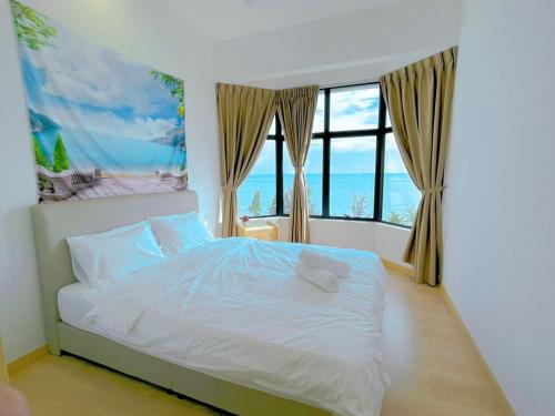 a bedroom with a bed and a large window at Mutiara Melaka Beach Resort by Minso in Tangga Batu