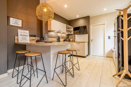 - une cuisine avec tabourets et réfrigérateur dans l'établissement Pleasant and bright chartreuse with terrace, à Toulouse