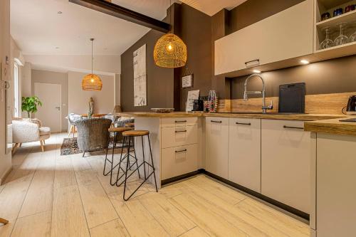 a kitchen with white cabinets and a dining room at Pleasant and bright chartreuse with terrace in Toulouse