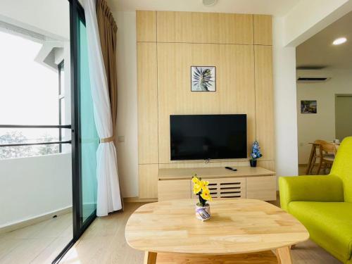 a living room with a television and a coffee table at Mutiara Melaka Beach Resort by Minso in Tangga Batu