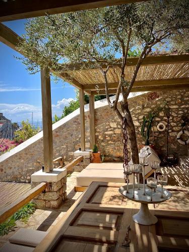 a patio with a tree and a swing at PortaDelMare deluxe suites in Hydra