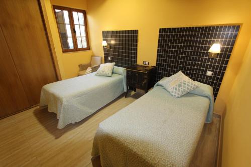 1 dormitorio con 2 camas, escritorio y ventana en Hotel Un lugar en la Vecilla en Dueñas