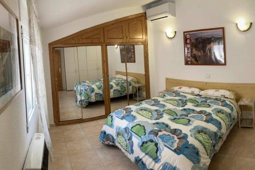 a bedroom with a bed and a mirror at Atico Mirador del Piélago in El Real de San Vicente
