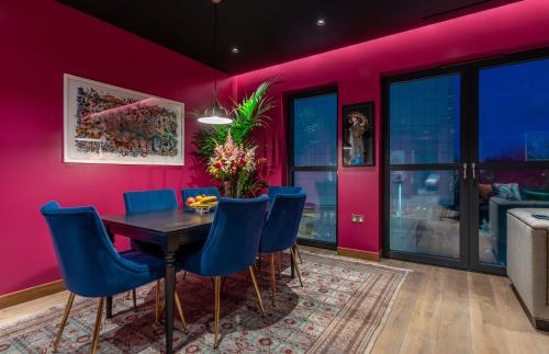 a dining room with a table and blue chairs at Hux Hotel, Kensington in London