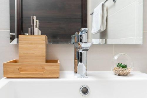 a bathroom sink with a faucet and a wooden holder at Calm Aesthetic 3 Bedroom Villa - E&G Homes in Dubai