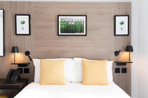 1 dormitorio con 1 cama y 3 cuadros en la pared en Princes Square, en Londres