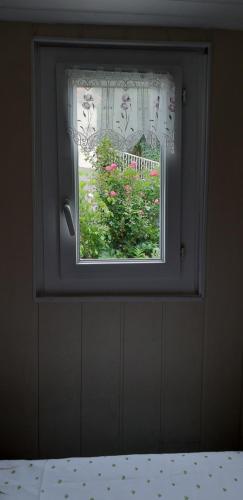 a window with a view of a garden with flowers at Les Ecrins in Les Mages