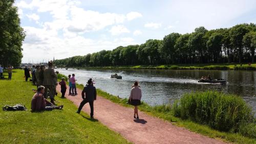a group of people standing on a path next to a river at Contact Hotel Utah Beach Carentan in Carentan