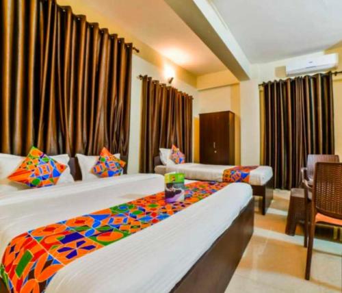 ein Hotelzimmer mit 2 Betten und einem Tisch in der Unterkunft Capital O Bvh Hospitality Near Pvr Ansal Plaza Greater Noida in Noida