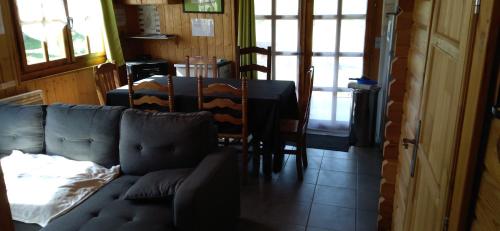 a living room with a couch and a table and chairs at chalets les 5 loups in Gerbépal