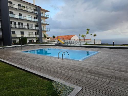 a swimming pool in front of a building at Penthouse Quinta Village Garajau in Caniço