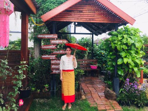 a woman holding an umbrella in front of signs at DE ROSE Hotel Chiang Mai in Chiang Mai