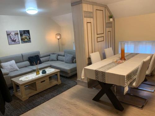 una sala de estar con una mesa y un sofá en Comme à la Maison, en Bruselas