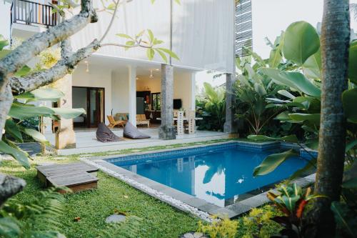 a house with a swimming pool in the middle of a garden at Villa Gading 2 in Ubud