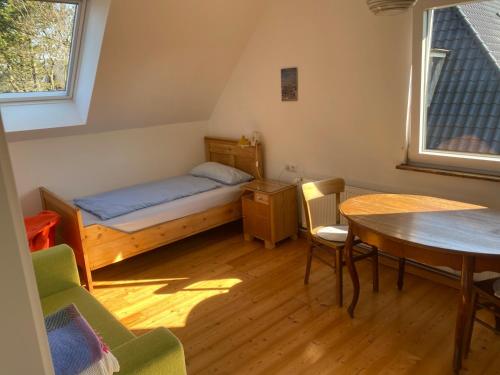 a small room with a bed and a table and chairs at Nolte Faarderhuuch 7 in Norddorf