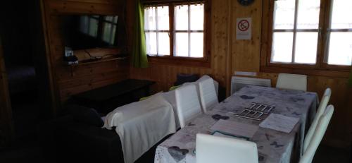 a dining room with a table and chairs and windows at chalets les 5 loups in Gerbépal
