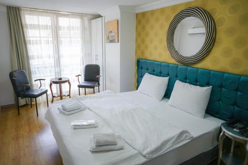 a bedroom with a large bed with a blue headboard at My Way Tera Butik Otel in Adalar