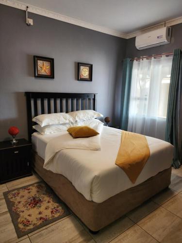 - une chambre avec un grand lit et une fenêtre dans l'établissement Minnestay Guest House, à Palatswe