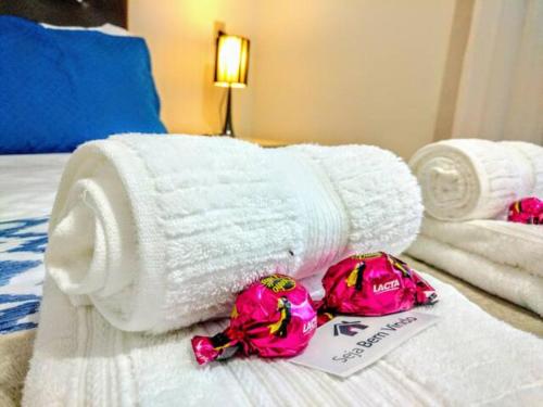 a pile of towels and flowers on a bed at Casa dos Franz in Jaraguá do Sul