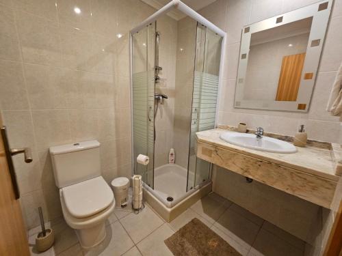 e bagno con doccia, servizi igienici e lavandino. di Penthouse Quinta Village Garajau a Caniço