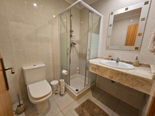 a bathroom with a shower and a toilet and a sink at Penthouse Quinta Village Garajau in Caniço