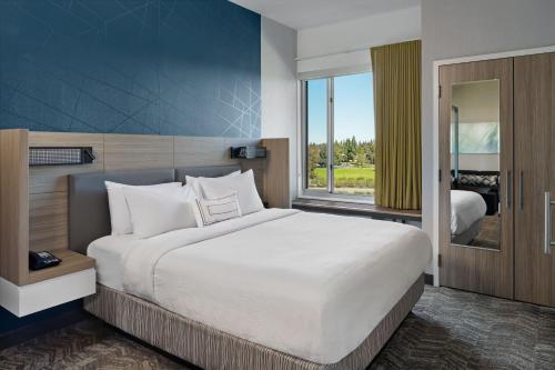 a bedroom with a large bed and a window at SpringHill Suites by Marriott West Sacramento in West Sacramento