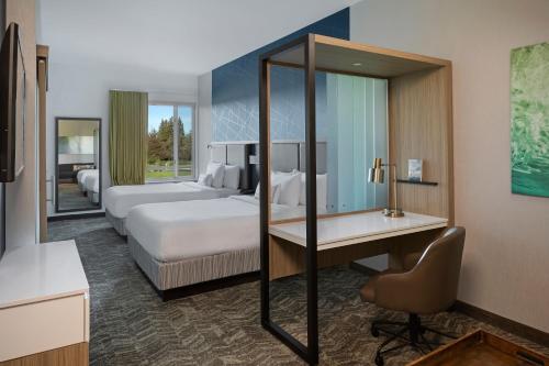 ウエスト・サクラメントにあるSpringHill Suites by Marriott West Sacramentoのベッド2台とデスクが備わるホテルルームです。