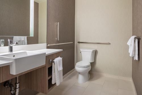 a bathroom with a white toilet and a sink at SpringHill Suites by Marriott West Sacramento in West Sacramento