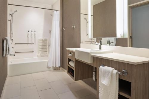 a bathroom with two sinks and a shower at SpringHill Suites by Marriott West Sacramento in West Sacramento