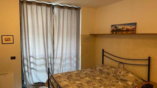 a bedroom with a bed in front of a window at Caravaggio Apartments in Bergamo