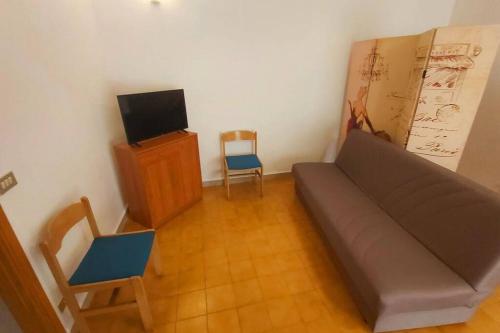ein Wohnzimmer mit einem Sofa und einem Stuhl in der Unterkunft Alloggio Open Space. in Alba Adriatica