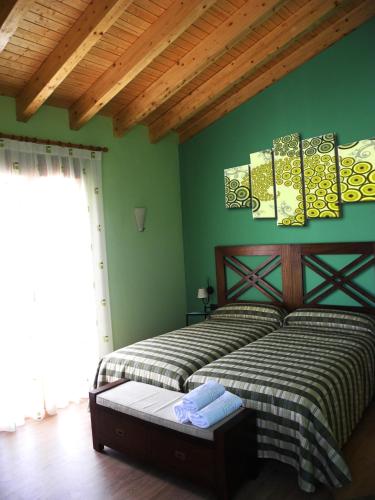 1 dormitorio con 2 camas y paredes verdes en El Balsetón, en Peñalba