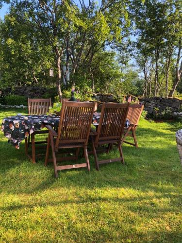 three wooden chairs and a picnic table in the grass at Valberg Gjestegård in Valberg