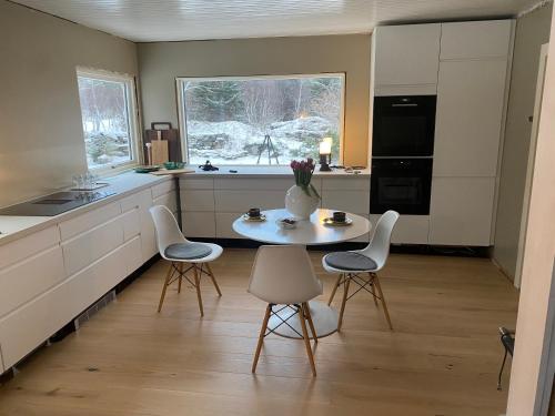 a kitchen with a table and chairs and a vase with flowers at Valberg Gjestegård in Valberg