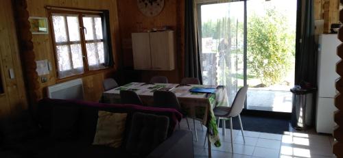 a dining room with a table and chairs and a window at chalets les 5 loups in Gerbépal