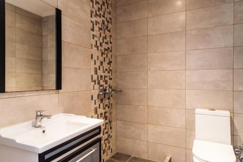 La salle de bains est pourvue d'un lavabo et de toilettes. dans l'établissement Oula Maisonettes Suites, à Kavos