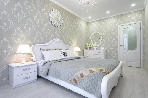 Schlafzimmer mit einem weißen Bett und einem Spiegel in der Unterkunft Красивая квартира в центре города с балконом in Odessa
