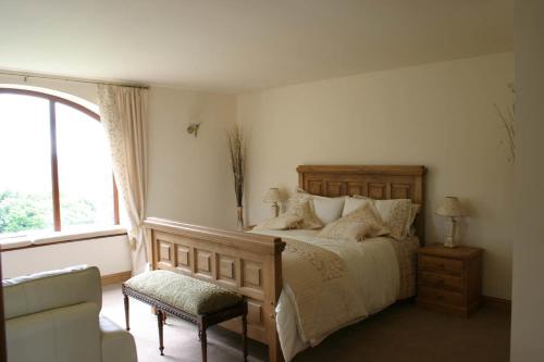 a bedroom with a bed and a chair and a window at Ackroyd House in Holmfirth