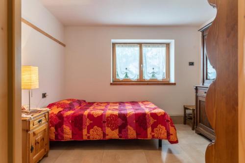 um quarto com uma cama e uma janela em Casa al Lez, Cavareno Ospitar em Cavareno