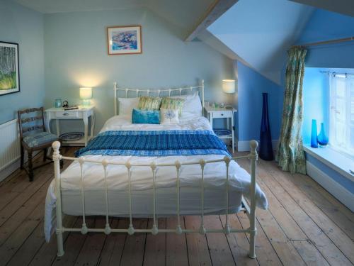 1 dormitorio con 1 cama grande y paredes azules en The Old Pharmacy, en Narberth