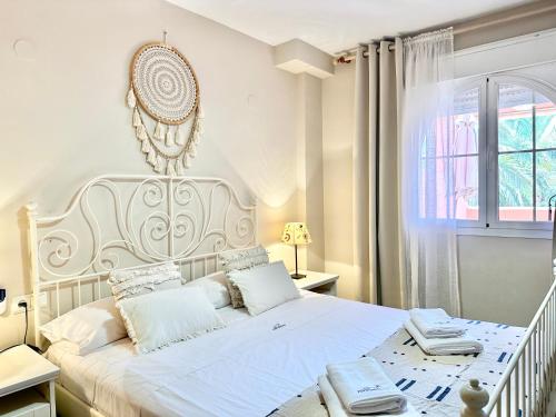 Biała sypialnia z białym łóżkiem i białymi poduszkami w obiekcie Alvarito Beach - EaW Homes w Marbelli