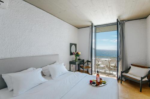 a bedroom with a bed with a view of the ocean at Apollo Resort in Agia Marina Aegina