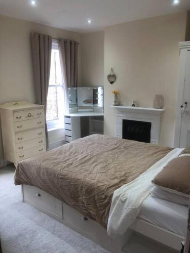 a bedroom with a bed and a dresser and a kitchen at Victorian Town House in Dover in Dover