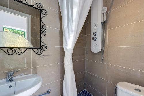 a bathroom with a shower curtain and a sink at Estudio Casa Marie in Estepona
