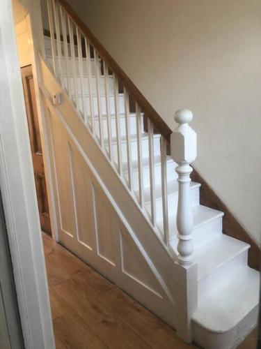 una escalera con barandillas blancas y suelo de madera en Victorian Town House in Dover en Dover