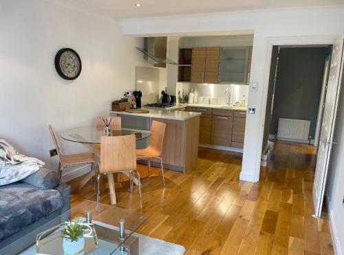 a kitchen and living room with a table and a couch at WATCH CHANGING OF THE GUARD AND WALK TO THE CASTLE! 2 Bedroom Apartment in Windsor